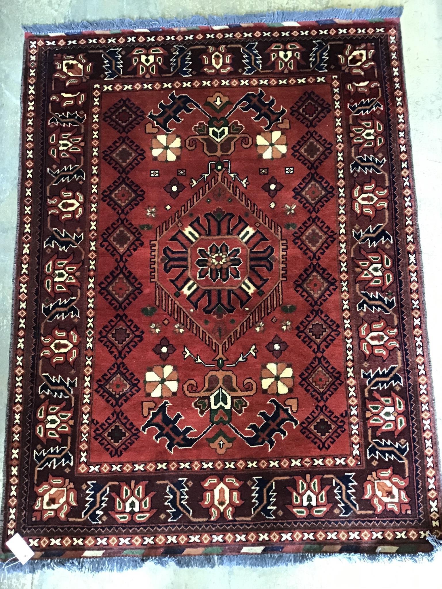 A Caucasian geometric red ground rug, 150 x 115cm